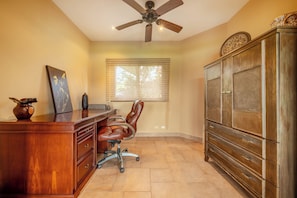 A room with a desk, chair, ceiling fan, window, and wooden cabinet. - Lake & Volcano Views: 2-unit Retreat w/ Hot Tub! (Tronadora)