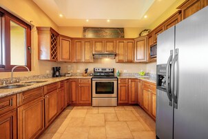 A kitchen with wooden cabinets, stainless steel appliances, and a granite countertop.