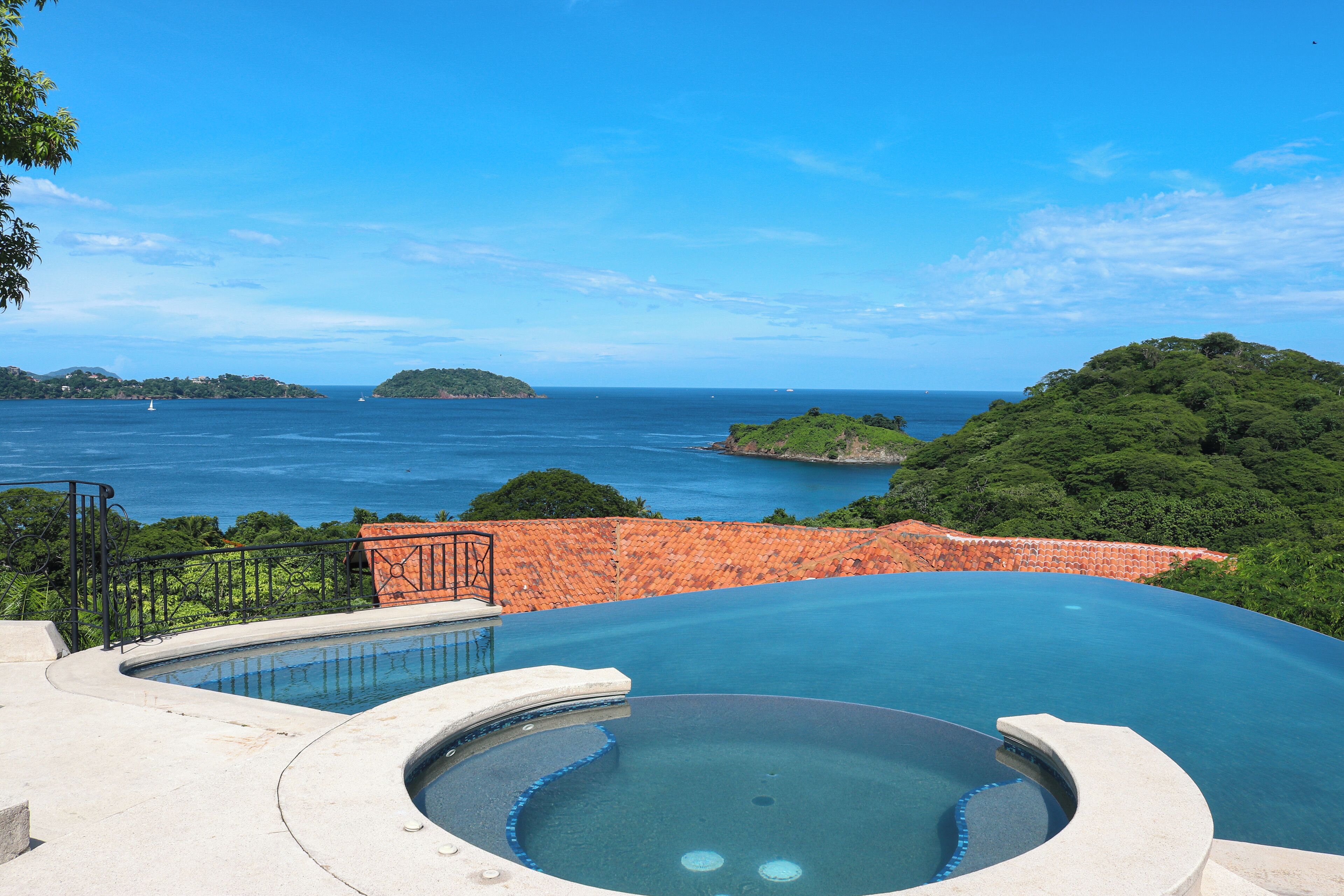 Piscina infinita com vista desobstruída do mar e ilhas ao longe.