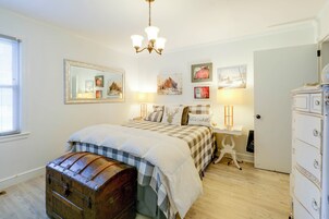 Un dormitorio con una cama grande, un aparador, un tocador, un espejo y decoración en la pared.