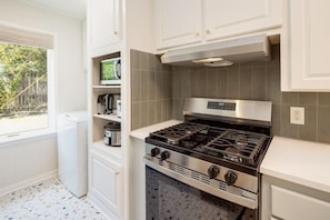 A kitchen with a gas stove, a microwave, and a built-in oven.