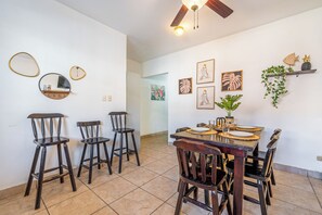 A dining area with a wooden table, chairs, and artwork on the walls. - Near Beach! Playas del Coco Condo w/ Pool (Sardinal)
