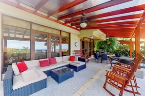 A spacious indoor area with a large sectional sofa, a dining table, and chairs. There is a view through large windows to the outdoors. - Bahia Pez Vela Resort: Condo w/ Beach Access! (Sardinal)