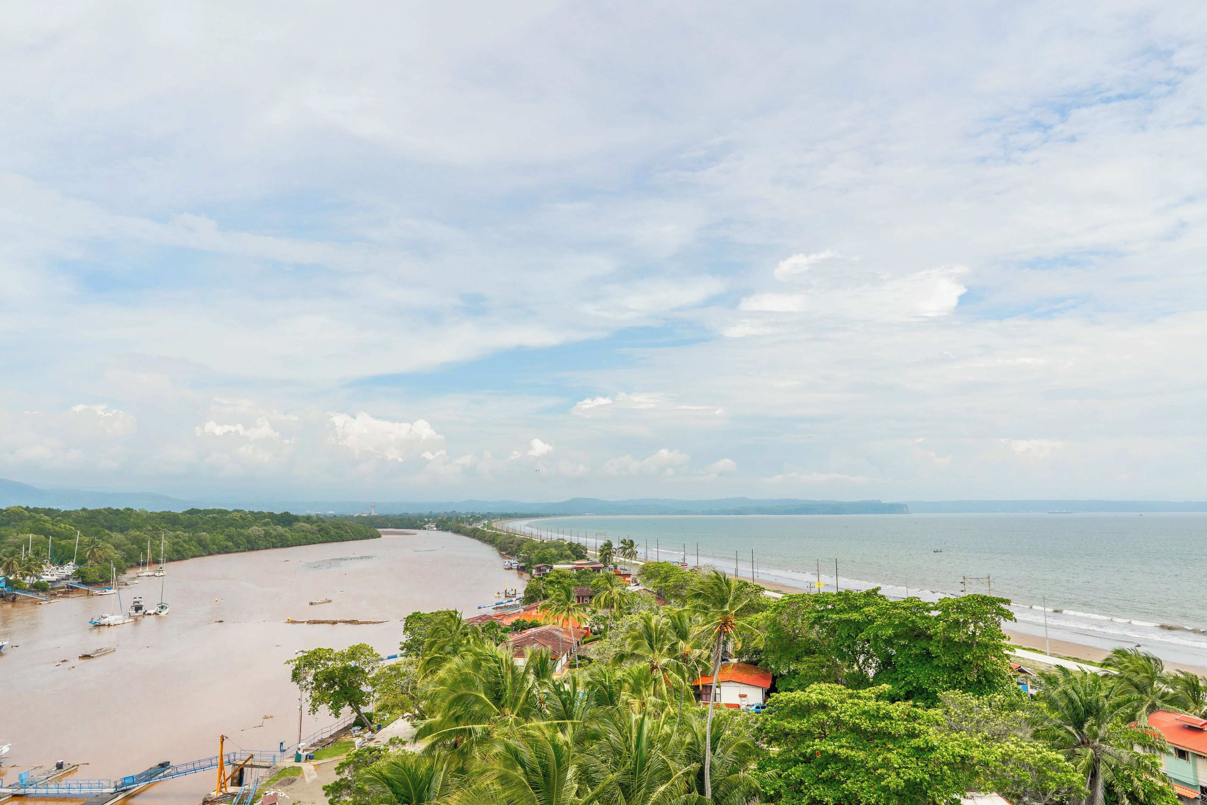 A coastal landscape with a beach, boats, and a clear sky.