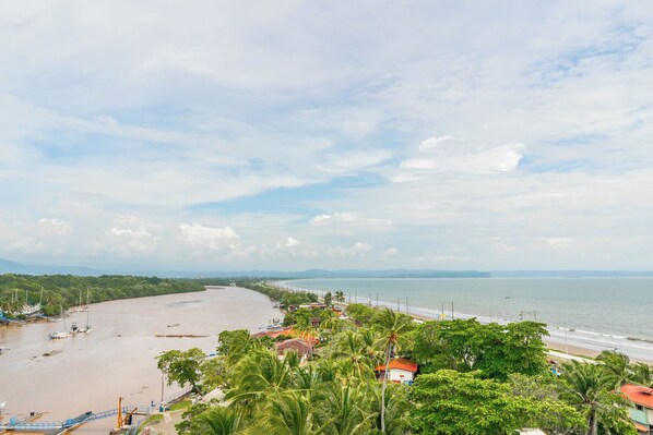 Un paisaje costero con playa, barcos y cielo despejado.