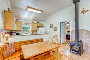 A kitchen with wooden cabinets, a dining table, and a built-in stove.