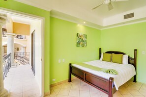 A hotel room with a bed, a ceiling fan, and a view of the outdoor area. - Bright 3BR Sunrise Resort 2nd-floor Balcony (Tamarindo)