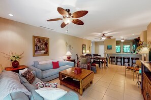 A spacious living room with a sofa, coffee table, and a dining area with chairs and a table. - Playas del Coco: Balcony, Near Beaches! (Sardinal)