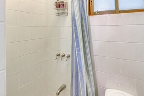Ein Badezimmer mit Dusche, Toilette und Handtuchhalter.