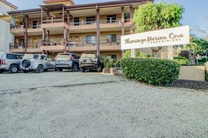 Ein mehrstöckiges Hotel mit einem Schild, auf dem 'Flamingo Marina Cove' steht. Vor dem Hotel befinden sich mehrere parkende Autos.