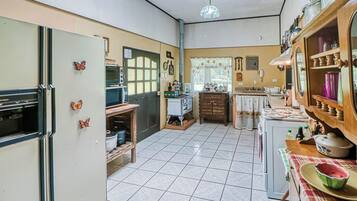 A compact kitchen with a refrigerator, stove, and various kitchen appliances.