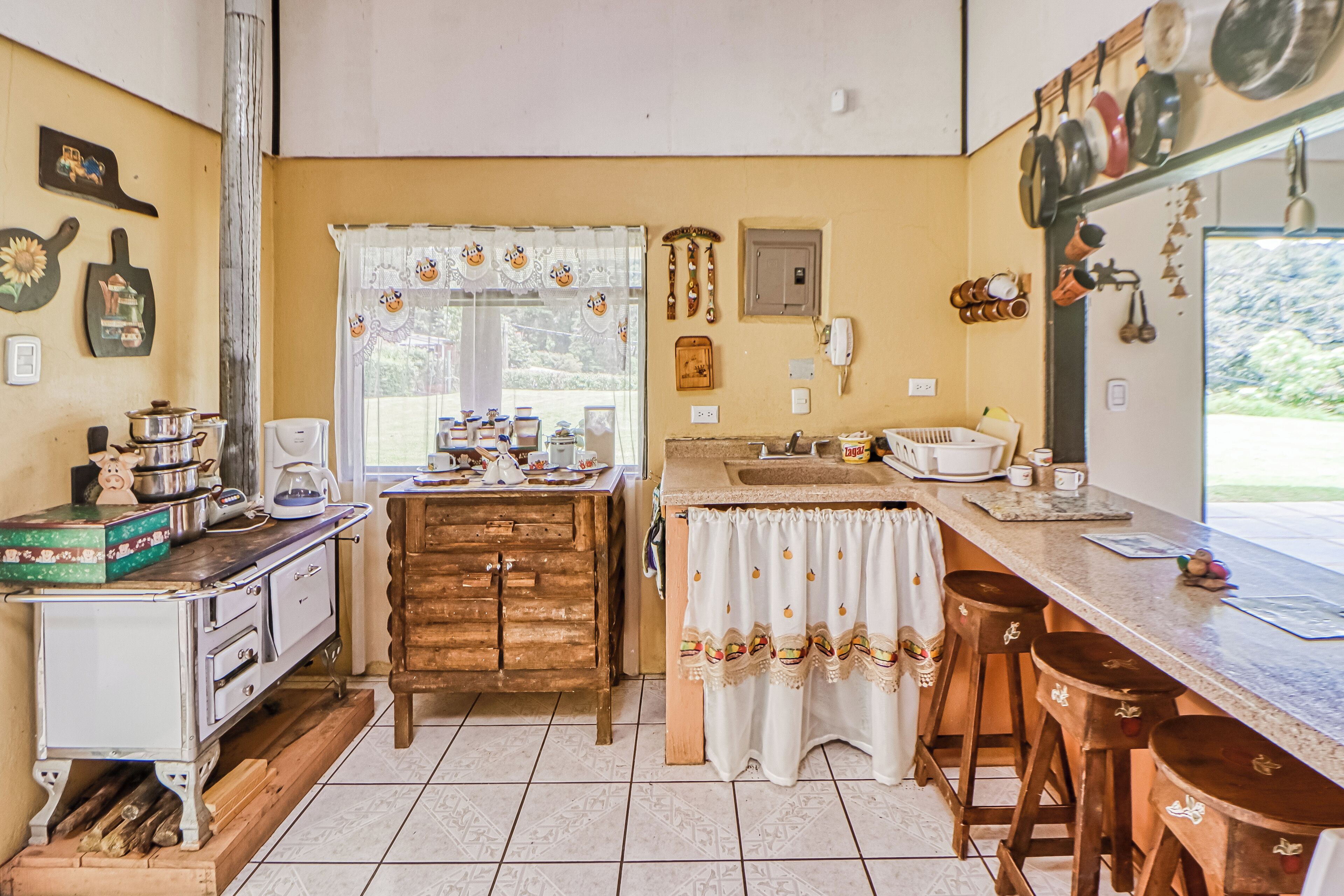 A kitchen with a wooden table, a coffee machine, and various kitchen utensils.
