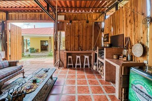 A rustic wooden interior with a bar area, a dining table with chairs, and a sofa. - Dog-friendly, Secluded, Game Room: Dota Mountain (Copey)