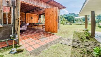 A wooden building with a covered patio area, a pool table, and a view of the surrounding landscape.