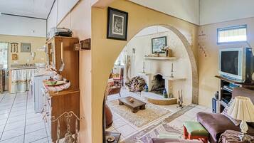 A cozy living room with a fireplace, a television, and a dining area with a table and chairs.