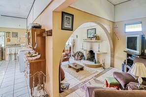 A cozy living room with a fireplace, a television, and a dining area with a table and chairs. - Dog-friendly, Secluded, Game Room: Dota Mountain (Copey)