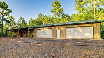 A two-story building with a gravel driveway, a covered porch, and a garage with two doors.