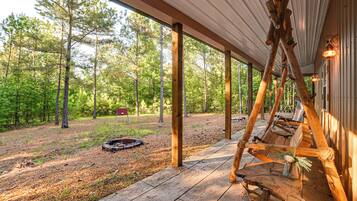 A covered outdoor area with wooden benches and a fire pit.