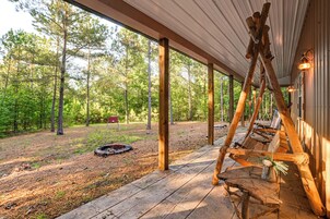 Un espacio al aire libre techado con bancos de madera y un hogar para fuego.