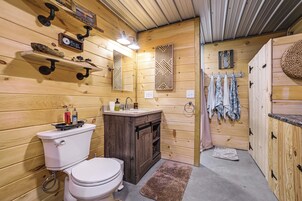 A wooden interior with a toilet, sink, and shower area.