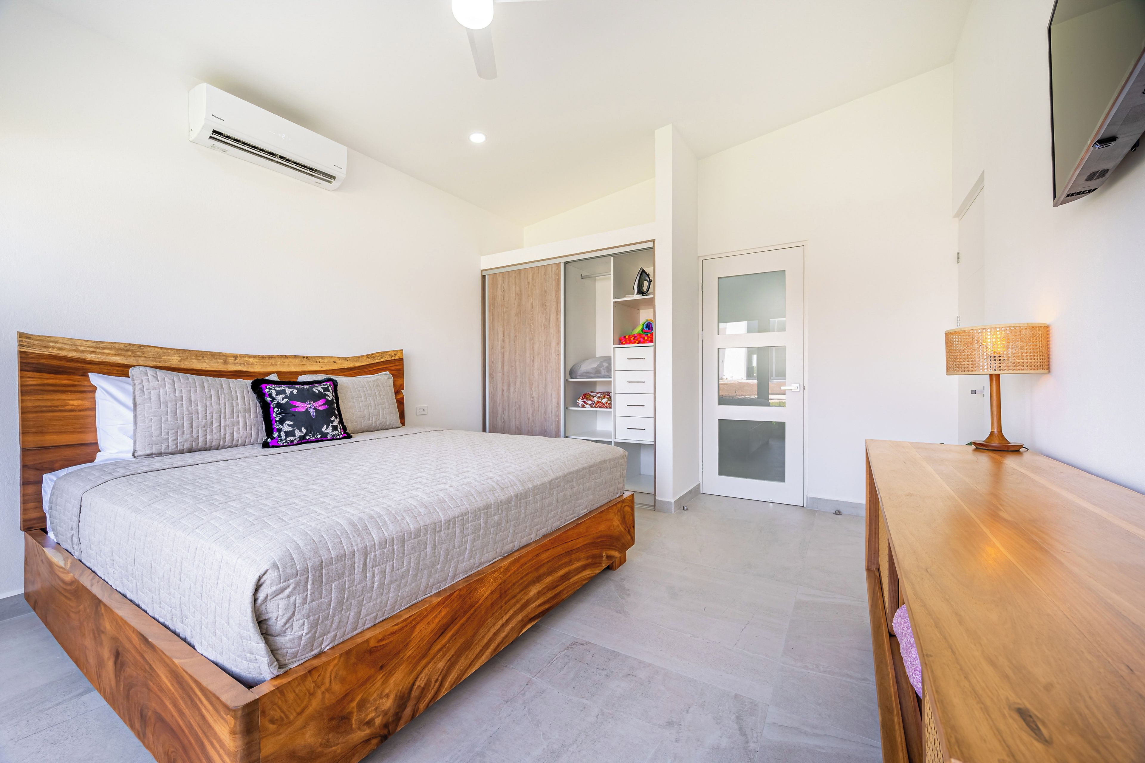A bedroom with a wooden bed, a wardrobe, and a bedside table.