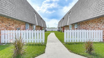 A pathway leading to a row of brick buildings with white picket fences.