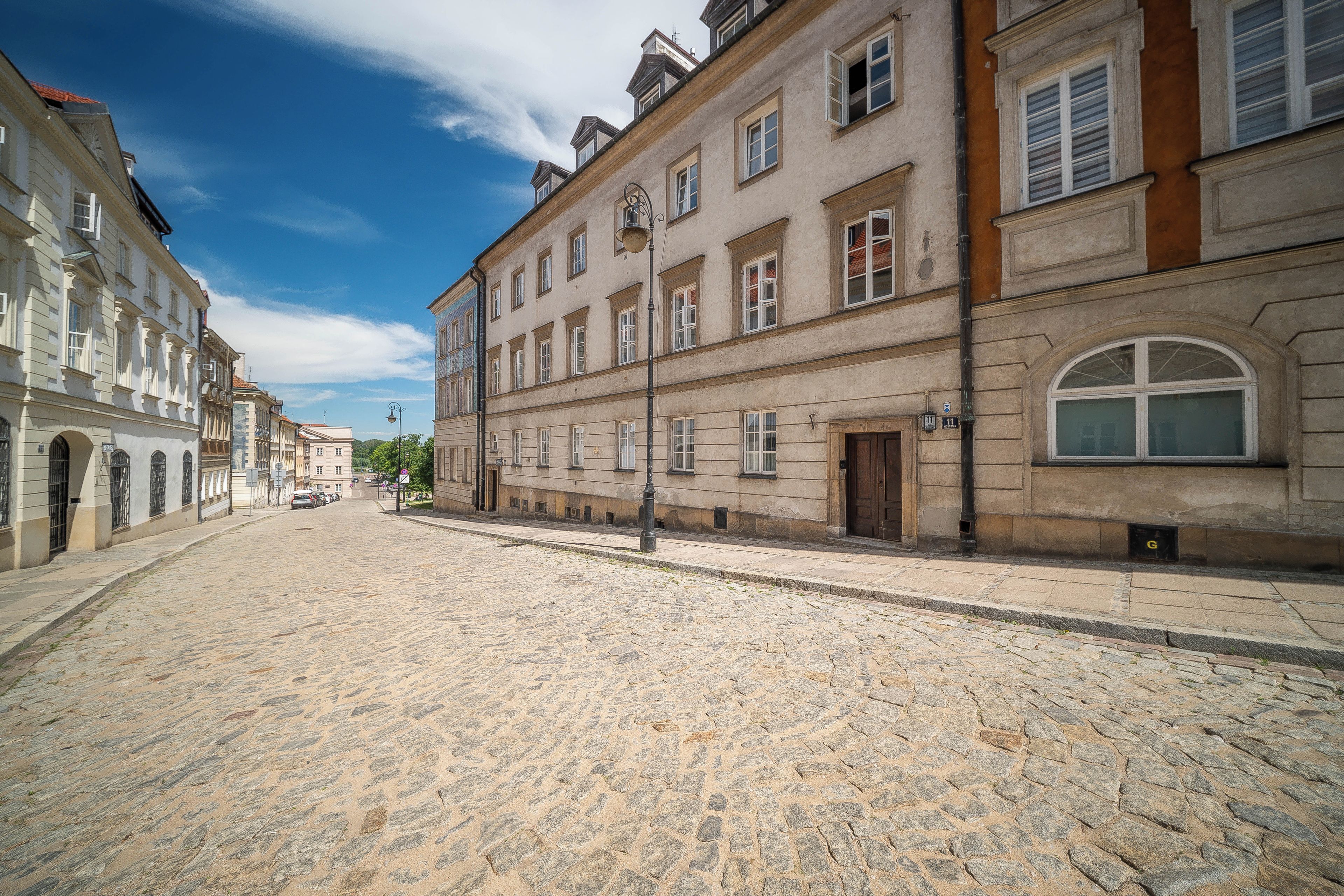 Une rue pavée bordée de bâtiments historiques, avec un ciel dégagé.