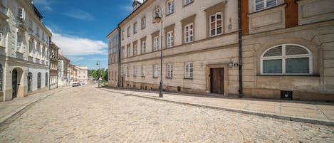 Una calle adoquinada flanqueada por edificios históricos, con cielo despejado.