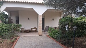 A paved pathway leading to a covered outdoor seating area with a table and chairs. - Villa 'Villetta Ninetta' with Mountain View, Wi-Fi and Air Conditioning (Carini(Pa))