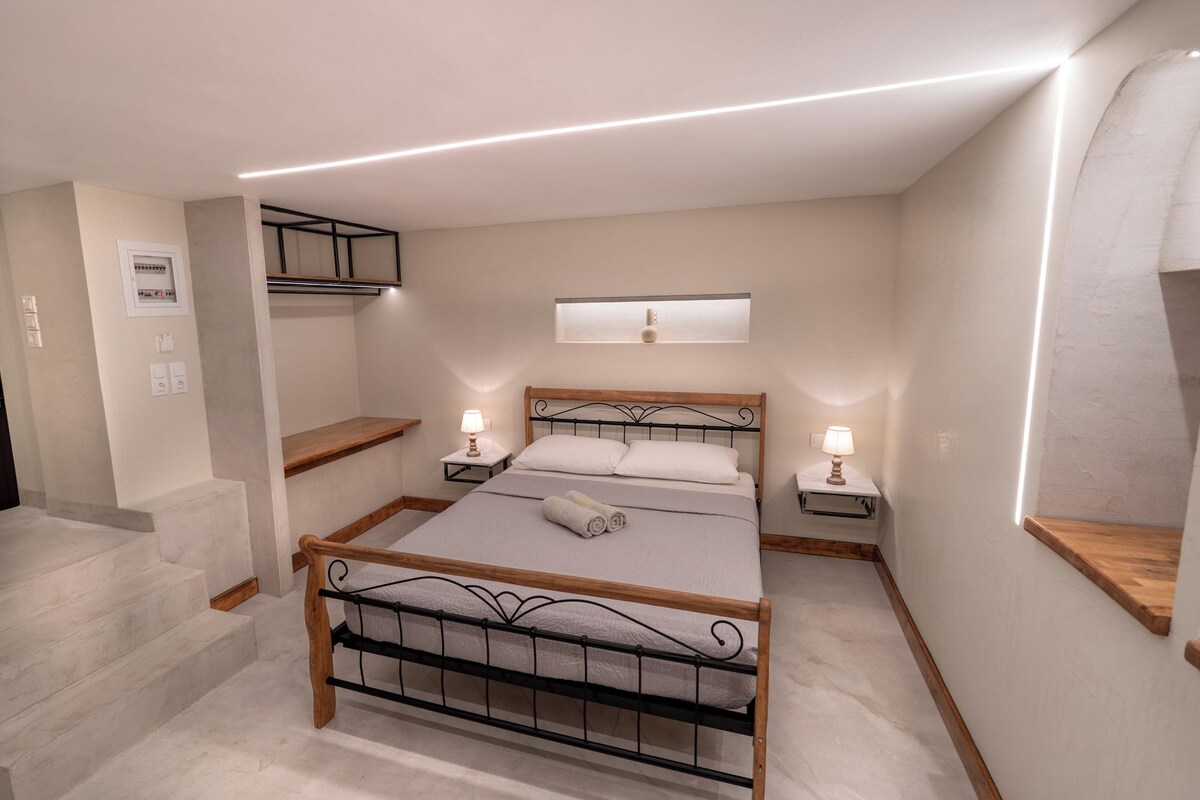 Ein Schlafzimmer mit einem Bett, Nachttischlampen, einem Fenster und einer eingebauten Ablage.
