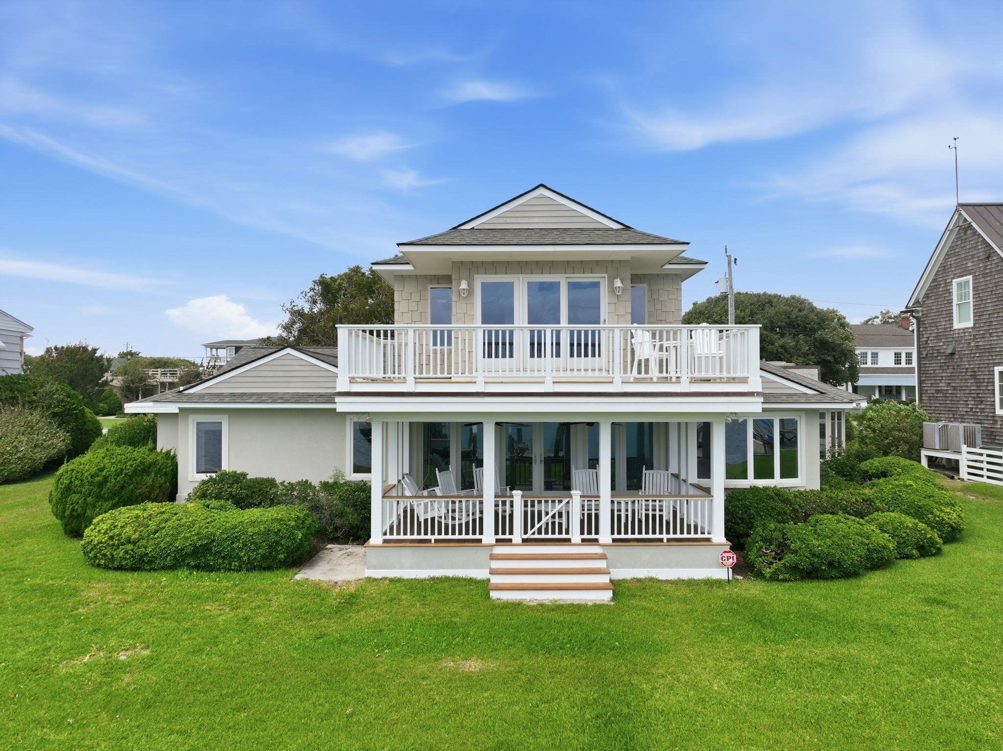 A two-story house with a balcony, a front porch, and a well-maintained lawn.