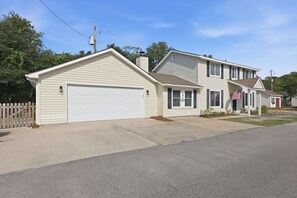 A two-story residential house with a garage, a front porch, and a small attached garage. - Laid Back Laurel-Pet Friendly in Beaufort, NC (Beaufort)