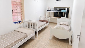 A small, compact room with two bunk beds and a single bed, featuring a tiled floor and a window with decorative glass. - Nomah Hostel 2 (São José do Rio Preto)