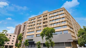 A multi-story building with a modern architectural design, featuring a flat roof and a series of balconies.