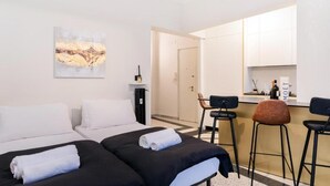 A hotel room with two beds, a kitchenette, and a bar area. - Luciano Luxury Apartment (Roma)