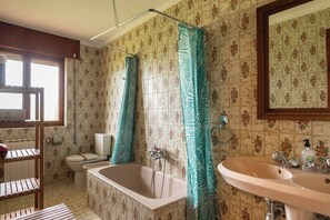 A bathroom with a bathtub, toilet, and sink.