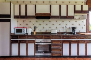 A kitchen with wooden cabinets, a microwave, a toaster, and a coffee maker.