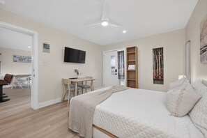 A hotel room with a bed, a desk, a chair, a television, and a wardrobe. - Winter Park Lodge II Unit E102M Mt views hotel room outdoor pool & hot tub (Fraser)