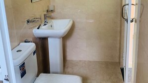Un baño con inodoro, lavabo y espejo.