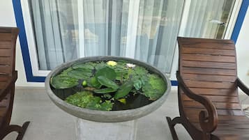A round table with a water feature in the center, flanked by two wooden chairs.