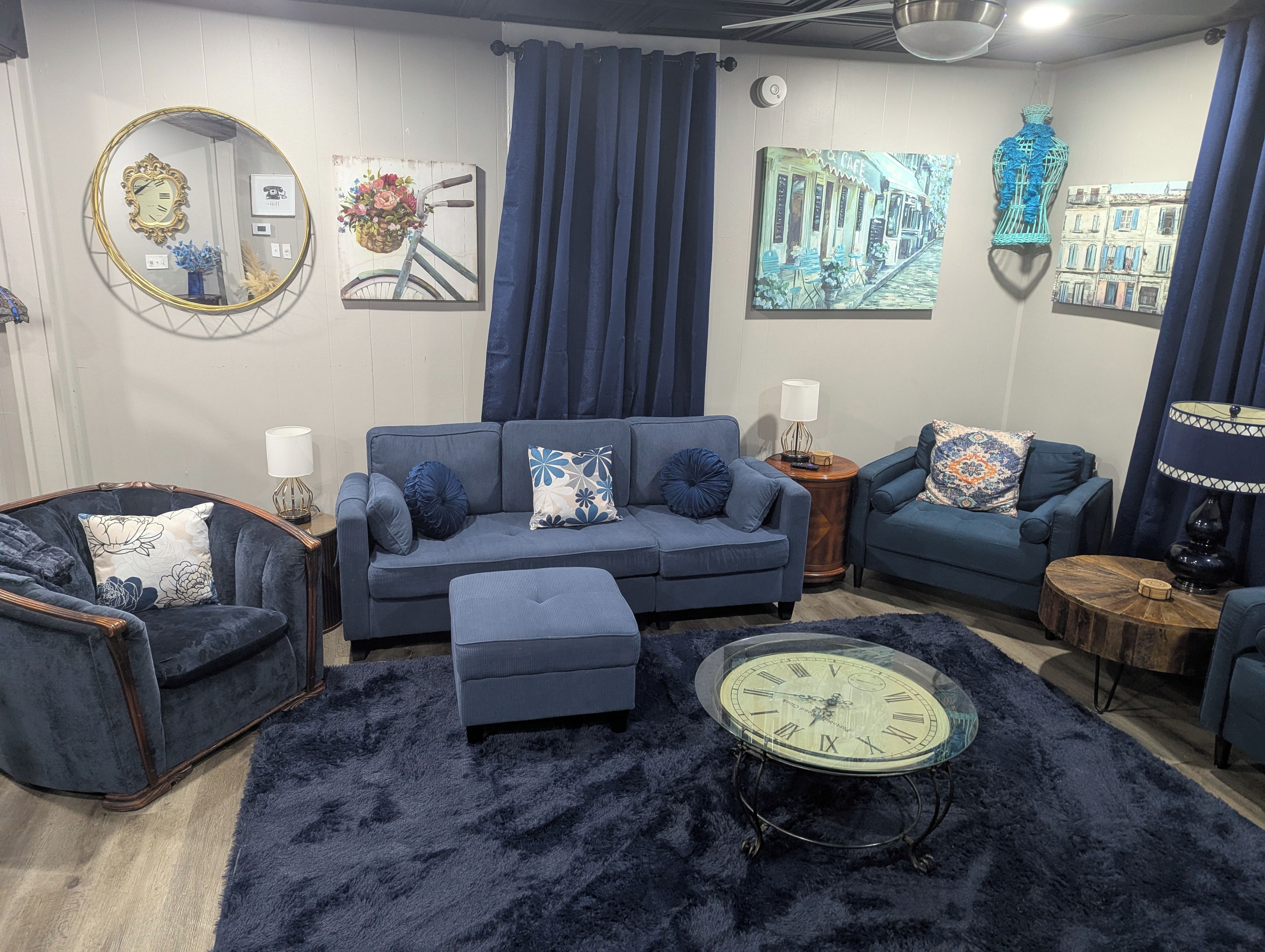 Ein Wohnzimmer mit einer Couch, Sesseln, einem Couchtisch und einem Teppich.