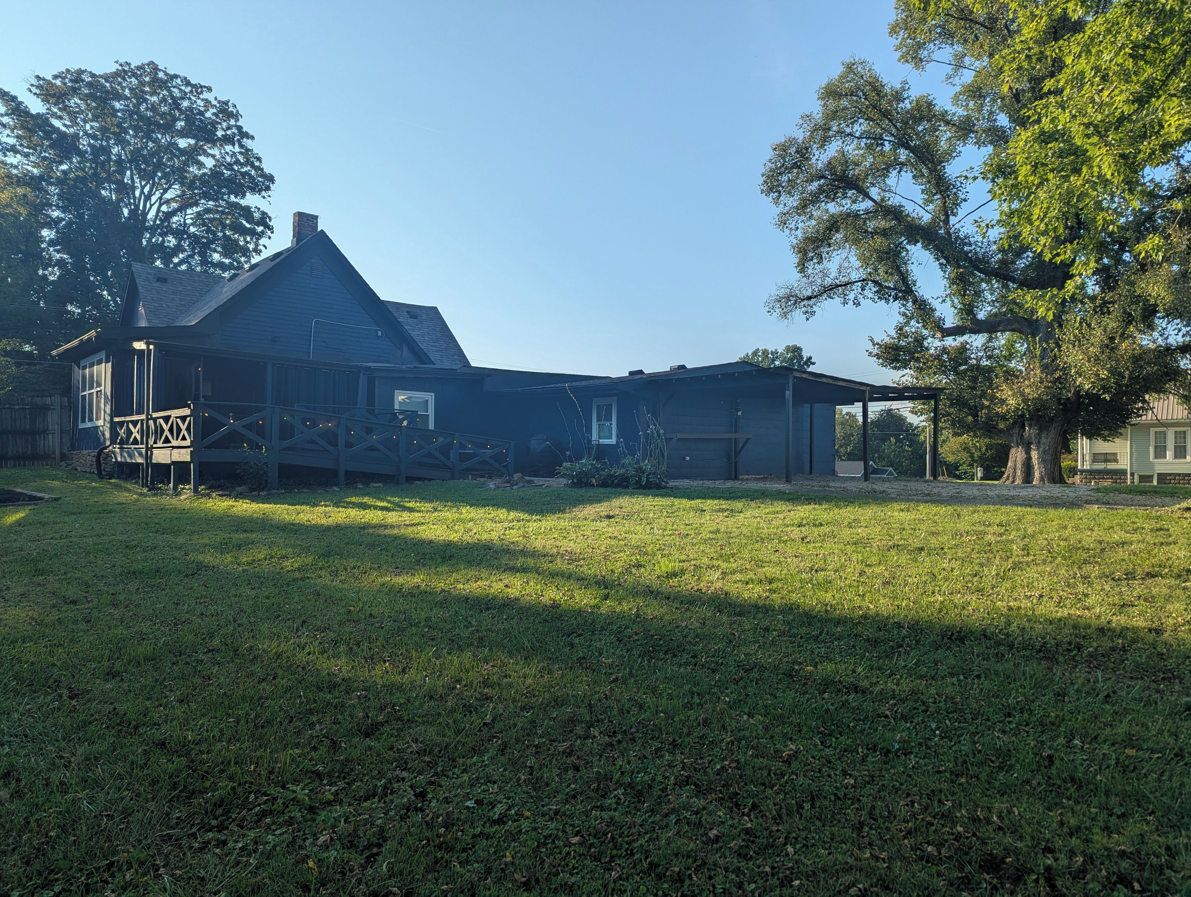 A two-story house with a porch, a garage, and a fenced yard.