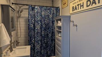 Un baño con ducha, inodoro, lavabo y un armario.