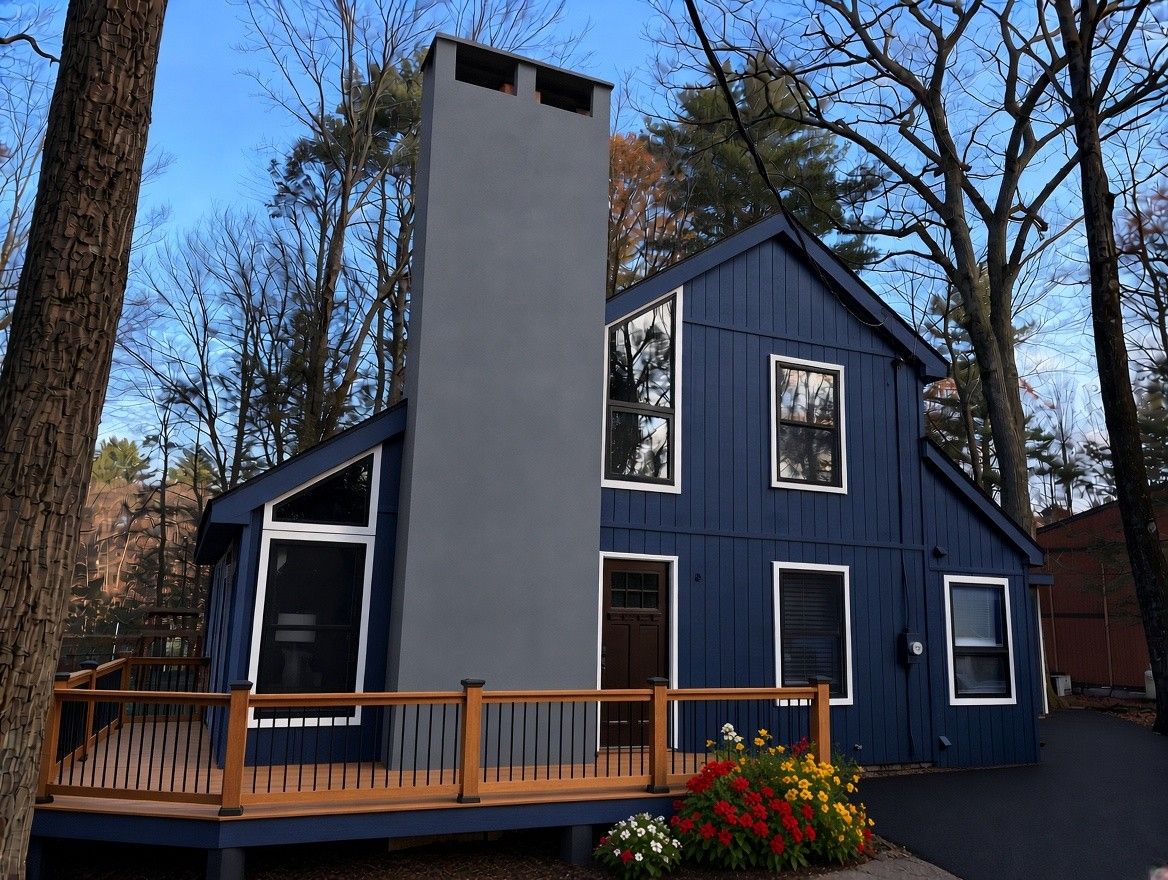 A two-story house with a balcony, a chimney, and a deck.