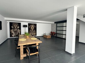 A modern dining area with a wooden table, black chairs, and two large wall-mounted artworks. - Villa with private pool - near beaches (Finestrat)