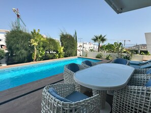 A poolside area with wicker furniture and a view of the cityscape. - Villa with private pool - near beaches (Finestrat)