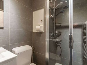 A modern bathroom with a glass-enclosed shower, a toilet, and a hand dryer. - Charming apartment in Méribel (Méribel)