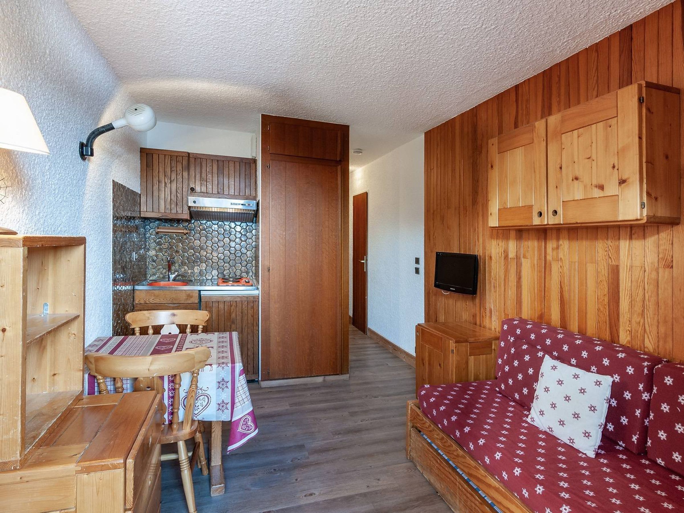 Een ruimtelijk ingerichte leefruimte met kitchenette, eethoek en een zithoek.