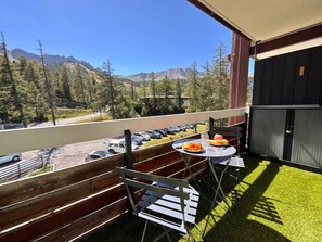 A balcony with a table and chairs, a grill, and a view of mountains. - Functional apartment near slopes - 4 guests (Vars)