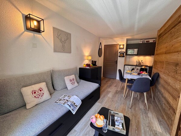 A compact living space with a sofa, a dining table, and a kitchenette. - Functional apartment near slopes - 4 guests (Vars)